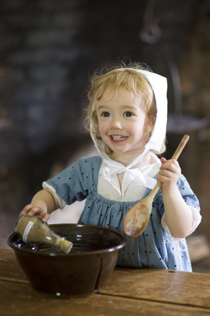 Child stirring with a wooden spoon
