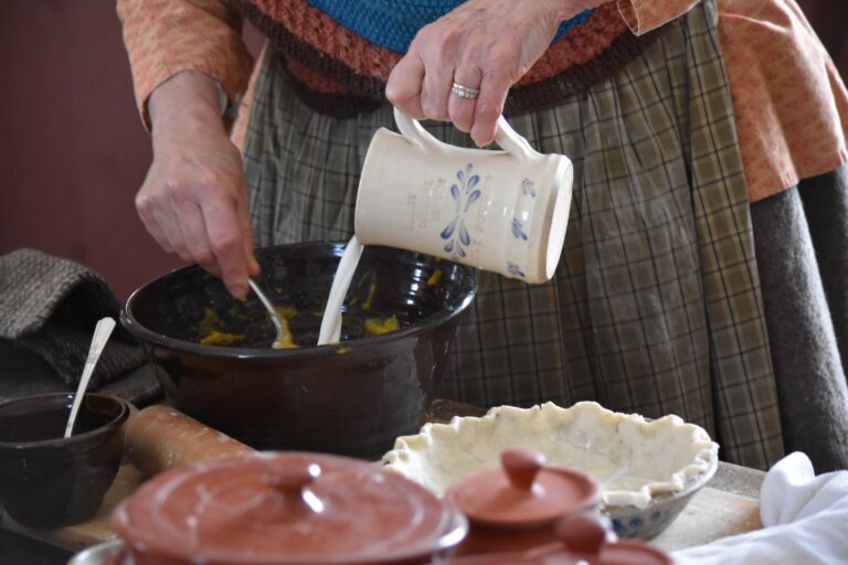 Hands pouring milk into pie mixture