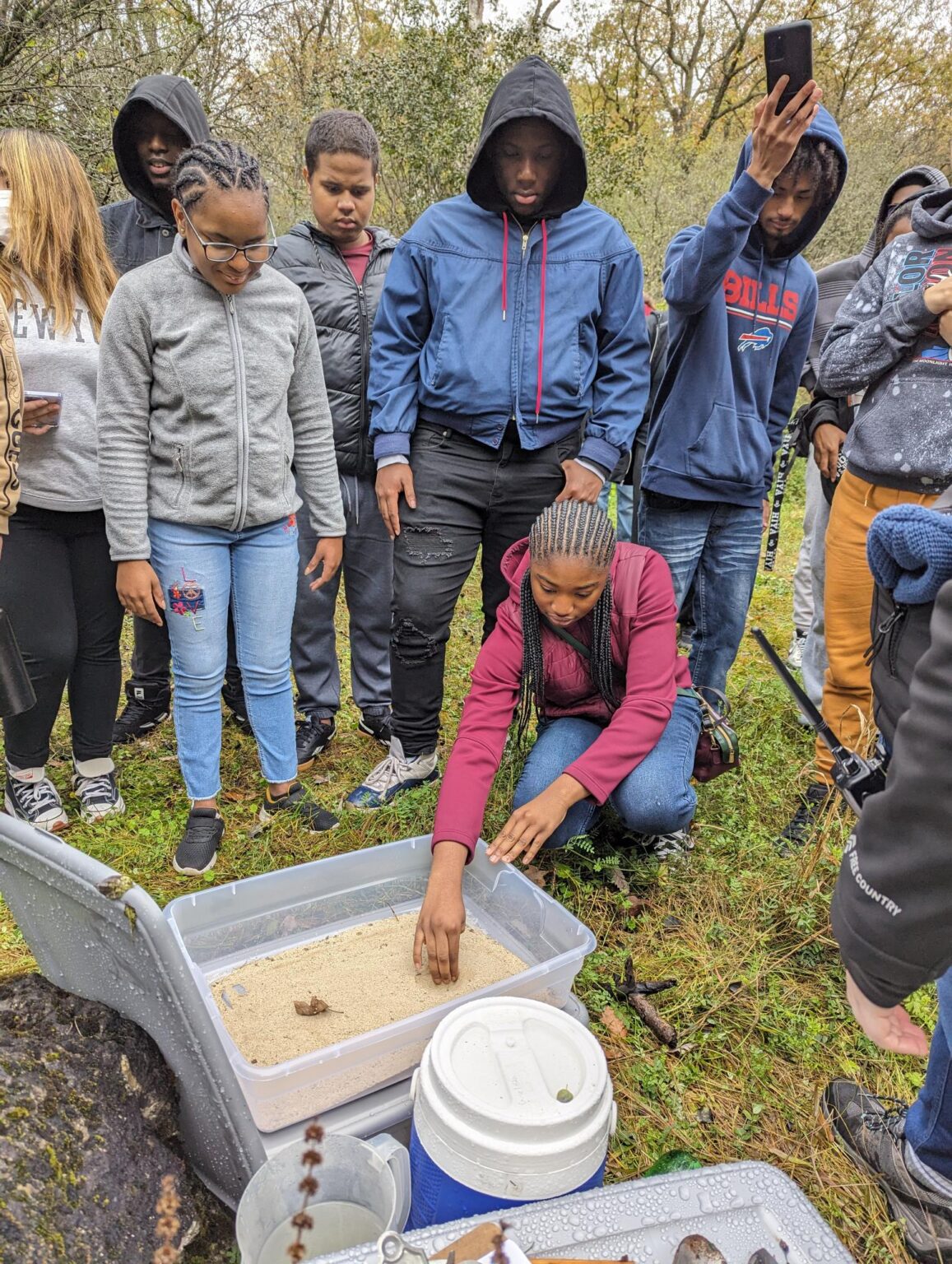Students looking in a container of sand
